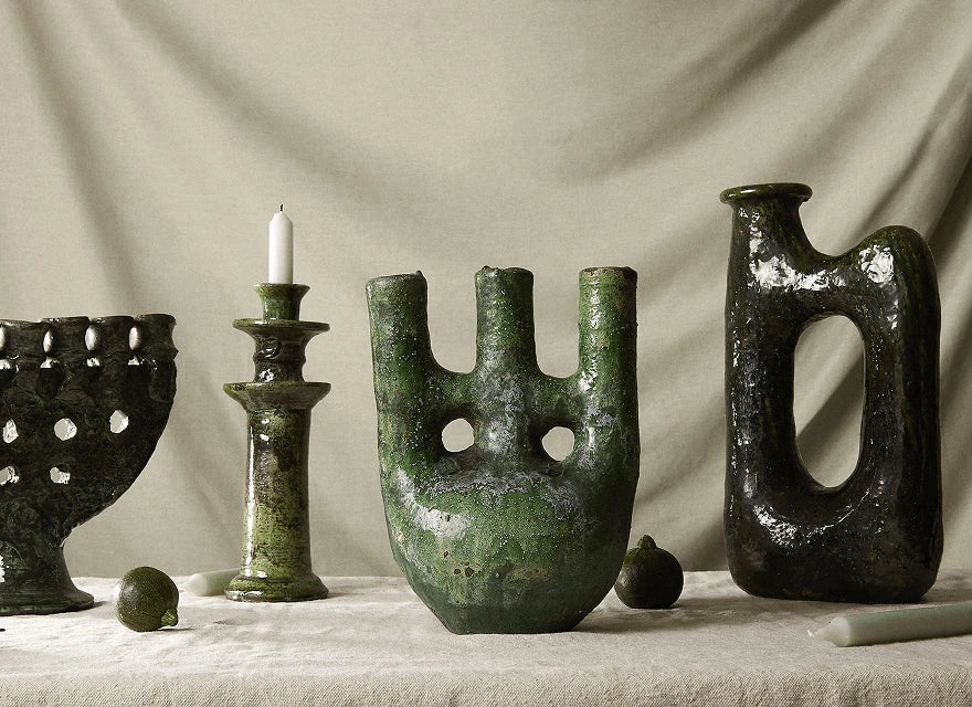 Tamegroute pottery with distinctive green glaze displayed on a handcrafted wooden table.